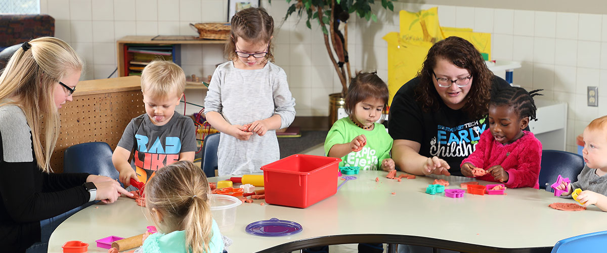 Early Childhood students at large craft table with children