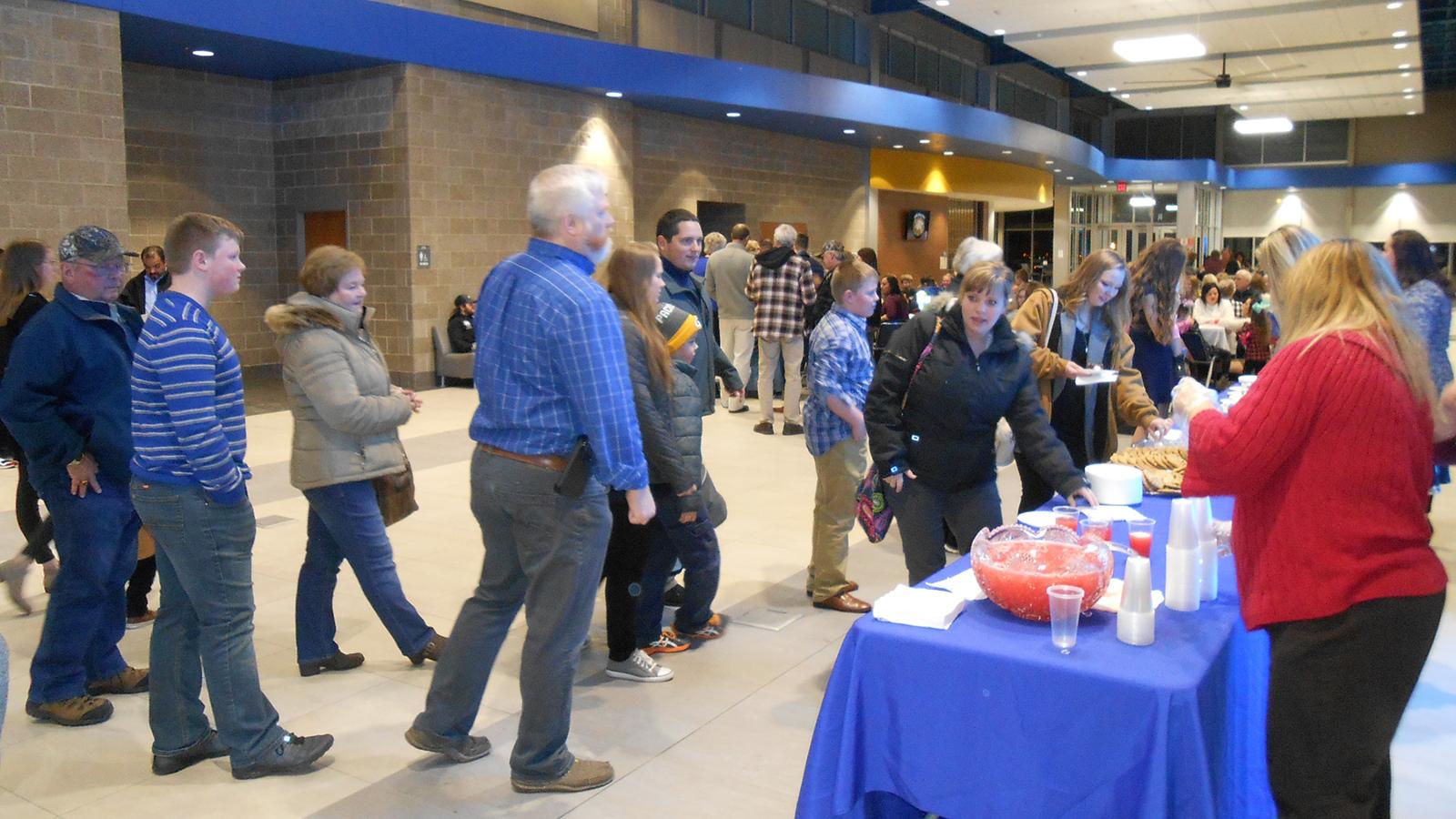 Group of attendees near serving table outside HUB auditorium