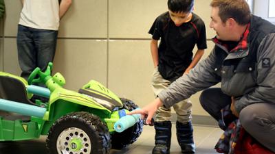 Micah checking out his new toy ride-on car with his dad, Jeff