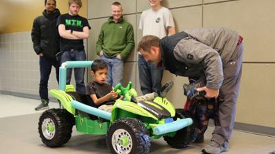 Micah sitting in his modified toy ride-on car for the first time