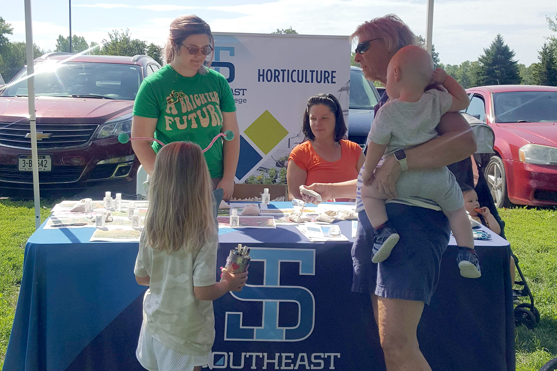 STC students at an outdoor booth with signage