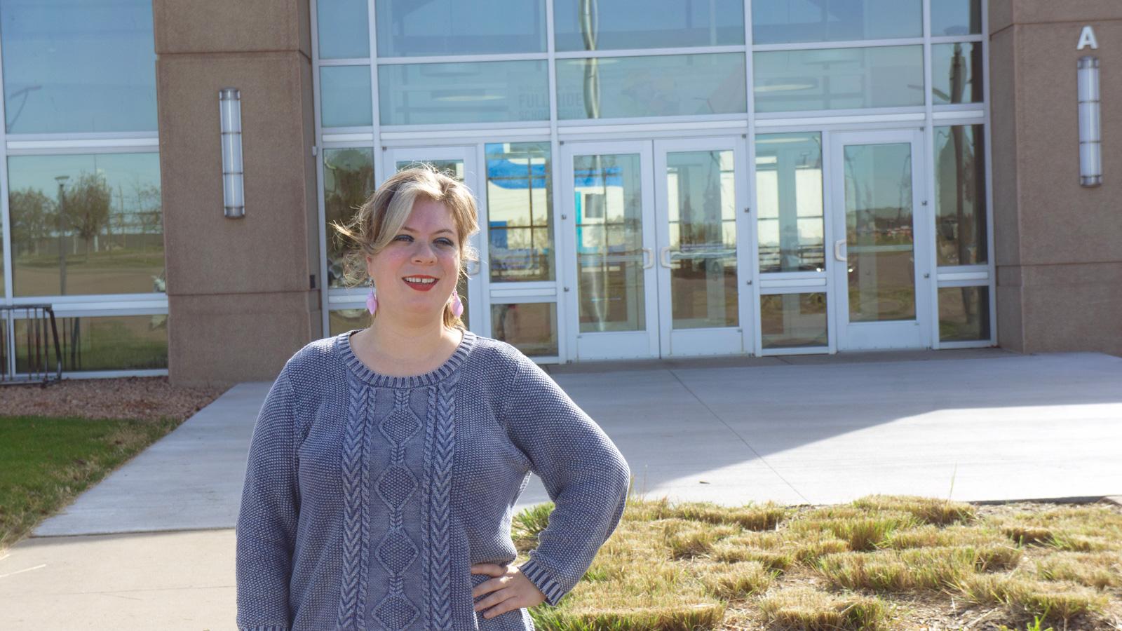 Anna Cole in front of the Mickelson Center on a sunny day. 