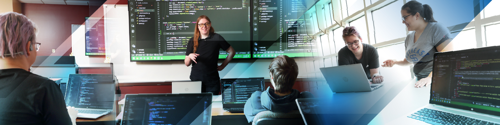 Students using computer with multiple monitors and writing code.