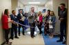 Group of presenters holding a blue ribbon to be cut. 