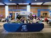 Welcome table at signing day with blue table cloth and admissions staff