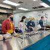 STC volunteers stand at serving line to help serve evening meal at The Banquet.