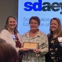 Tami Skorcewski, center, accepts SDAEYC award at 2023 annual conference.